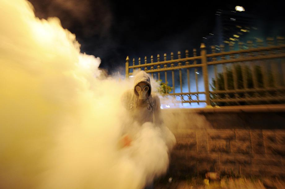 A protestor runs away from tear gas during clashes with Turkish riot policemen between Taksim and Besiktas in Istanbul on June 3, 2013 during a demonstration against the demolition of the park.