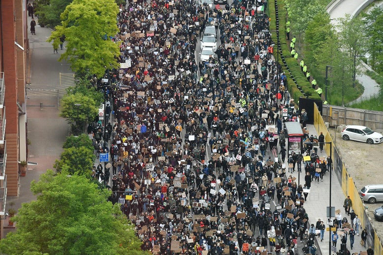 Demonstrators hold placards as they attend a protest march to the U.S. Embassy in London on June 6, 2020.