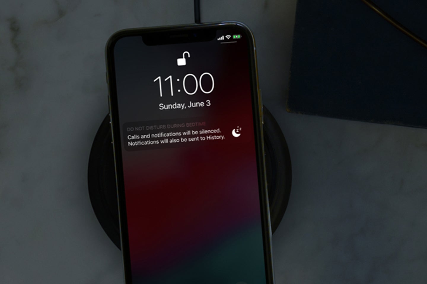 An iPhone with a dimmed display, using Apple's new Do Not Disturb during bedtime feature.
