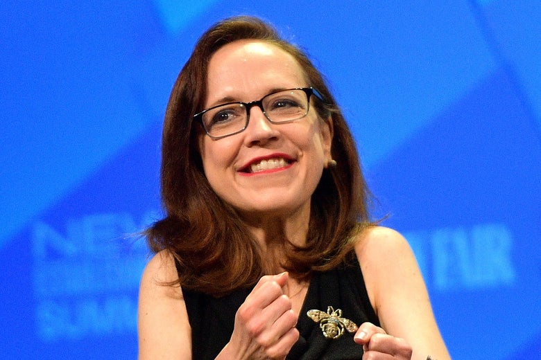 White woman in front of a microphone on a stage.