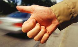 Man hitchhiking, Close-up of hand thumbing ride.