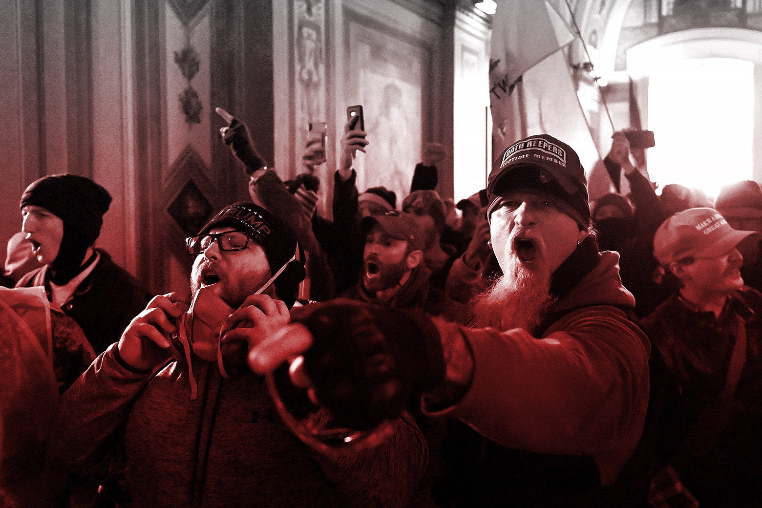 A mob of rioters storm the U.S. Capitol on Jan. 6, 2021, shouting and waving their cellphones and flags.
