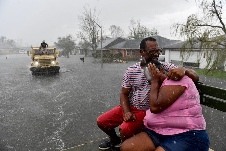 People react as a sudden rain shower soaks them with water while evacuating from their homes.