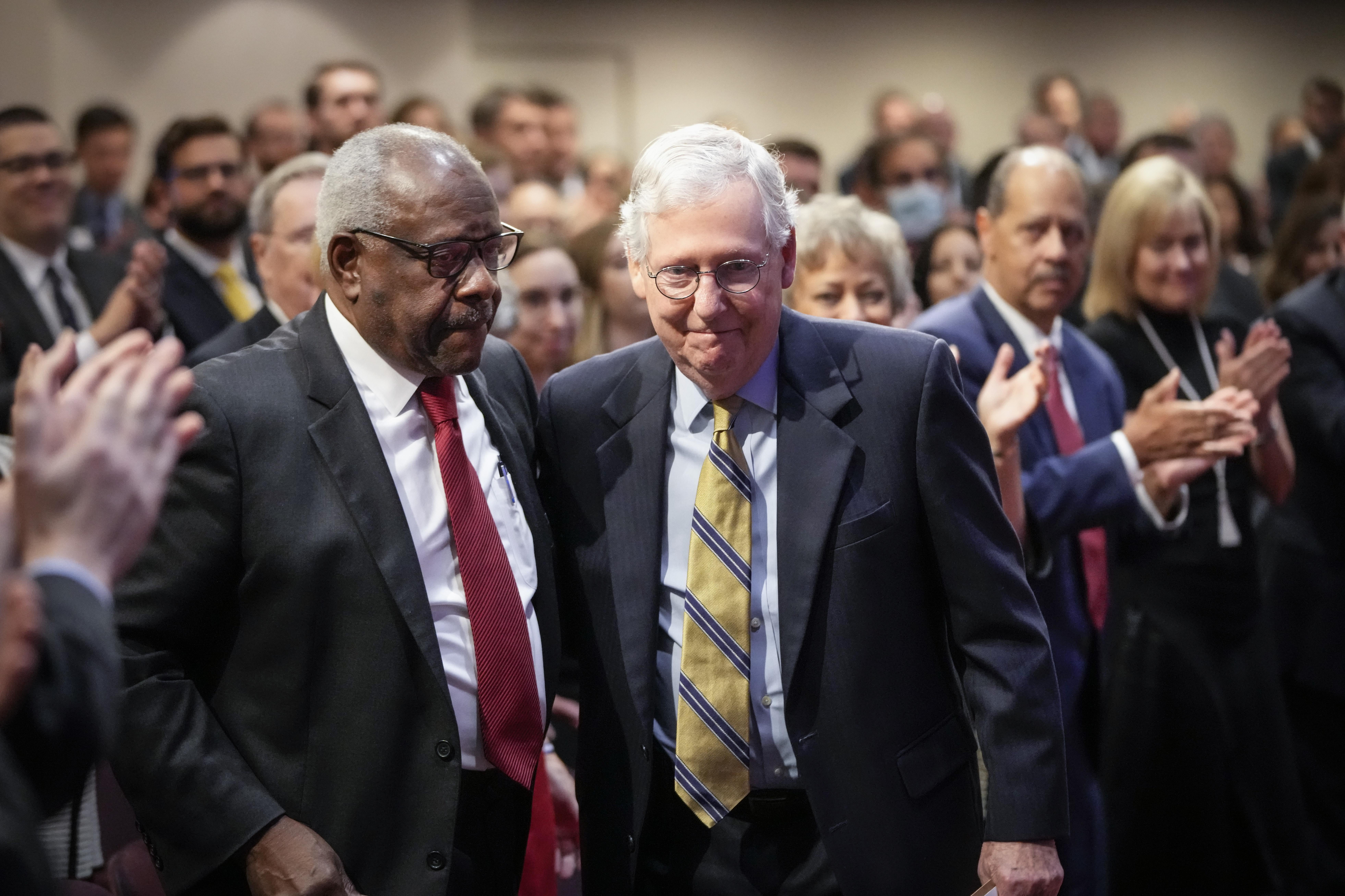 Clarence Thomas and Mitch McConnell looking amiable in a crowd.