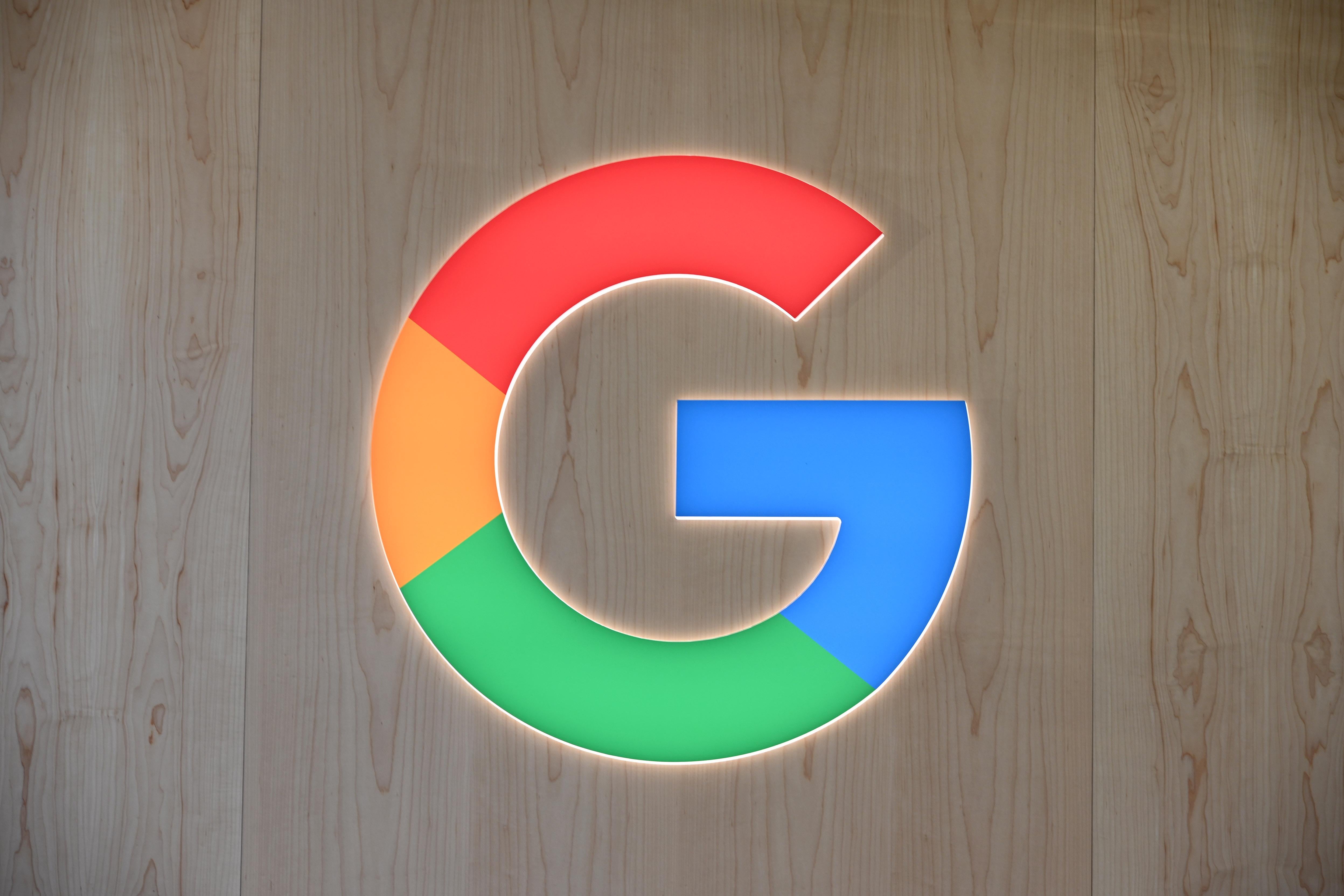 The "G" Google logo against a wood-grain background