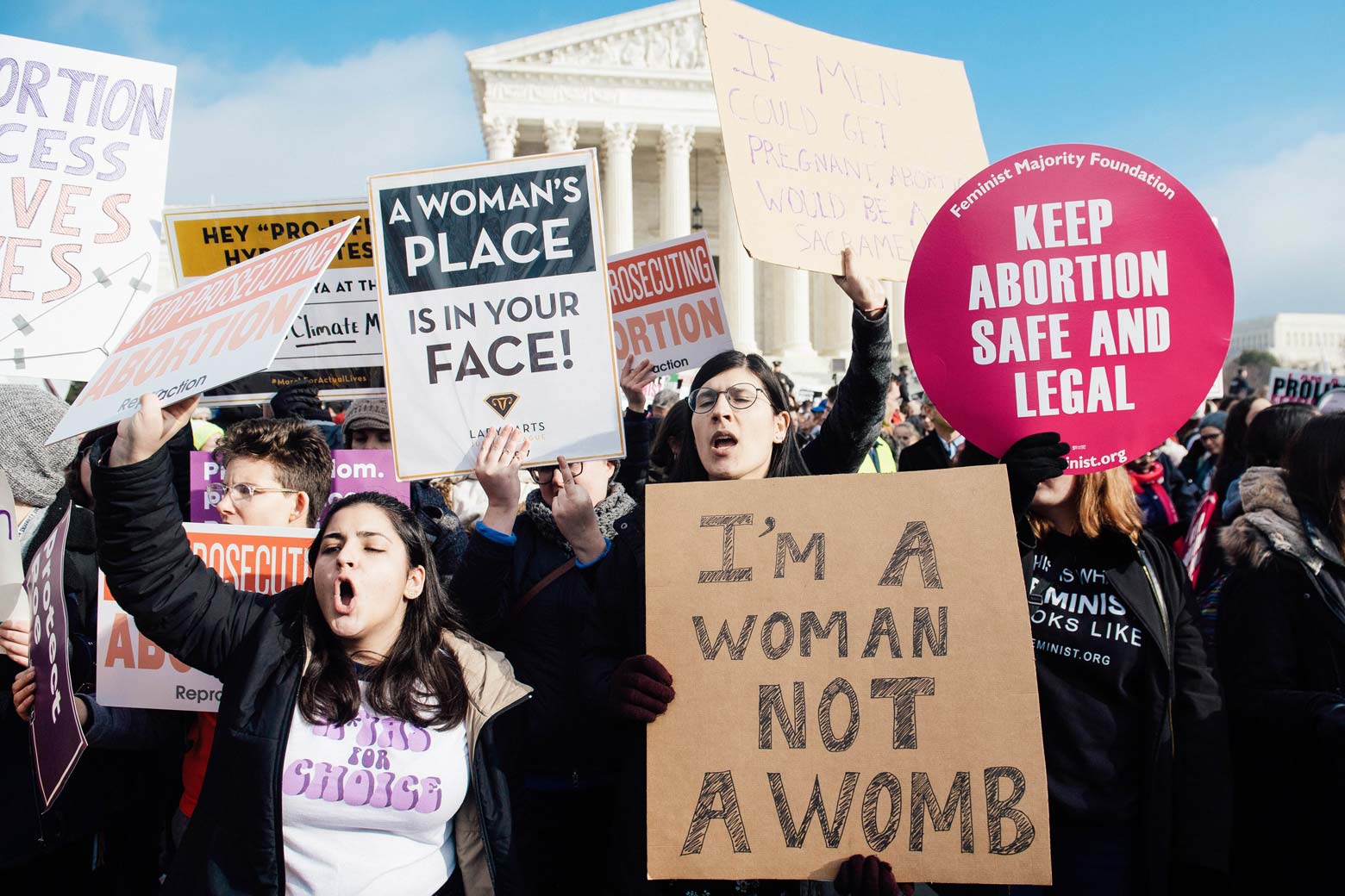 Pro-choice activists hold signs in response to anti-abortion activists participating in the March for Life outside the Supreme Court.