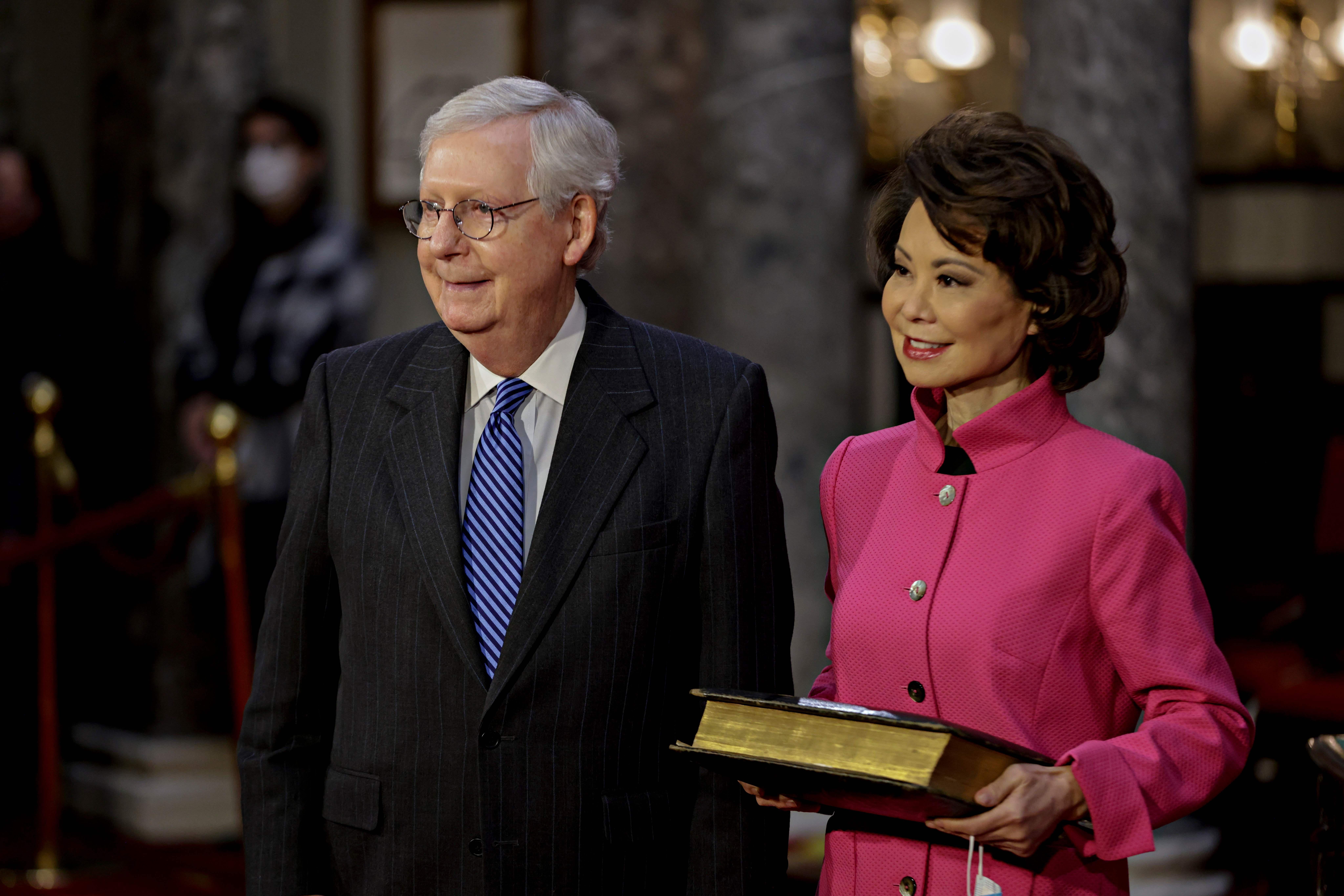 Chao holds a bible next to husband Mitch McConnell during a swearing-in ceremony at the U.S. Capitol. 