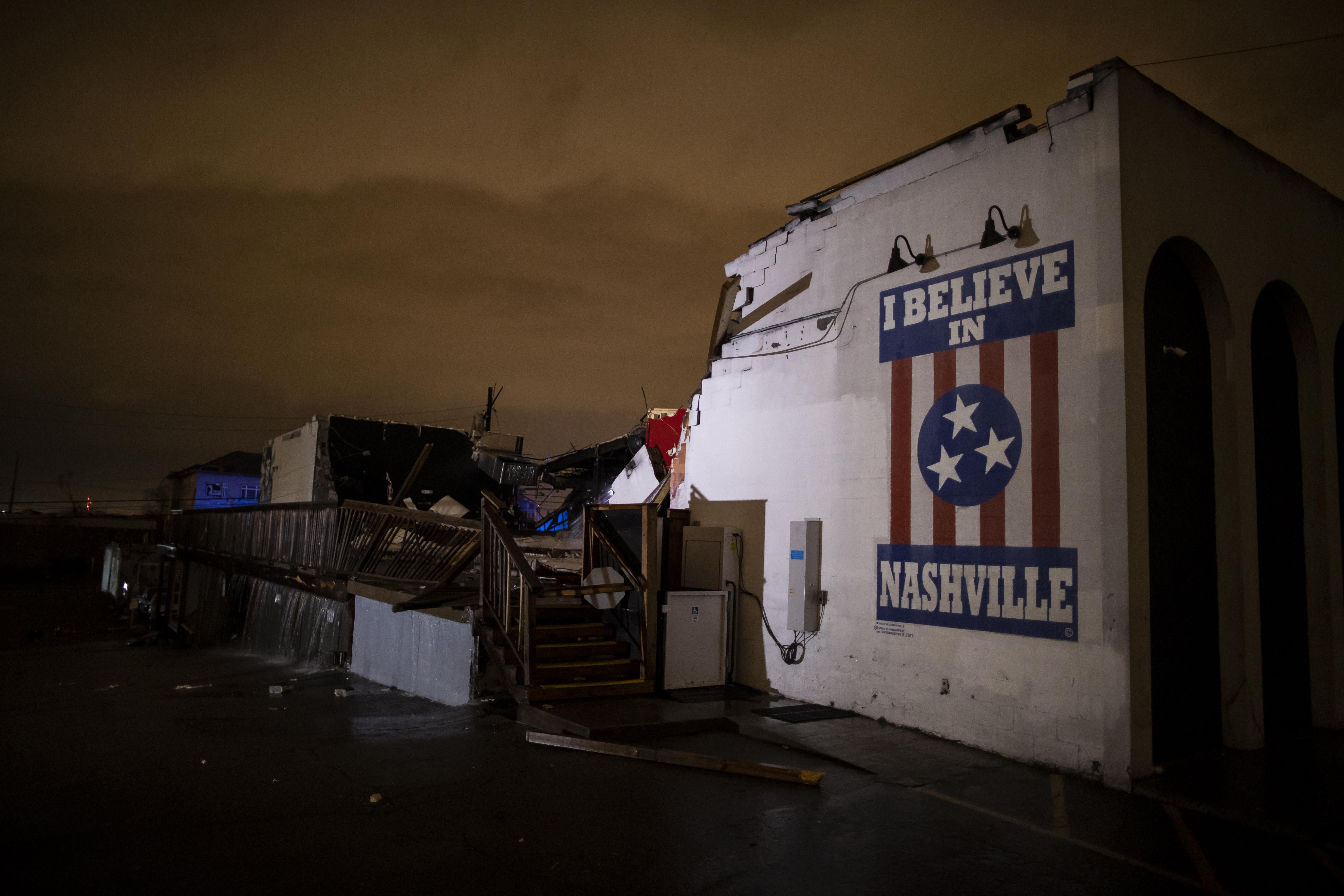 The wreckage of the Basement East club. Much of the building collapsed, but a wall with a mural that reads "I Believe in Nashville" remains standing.