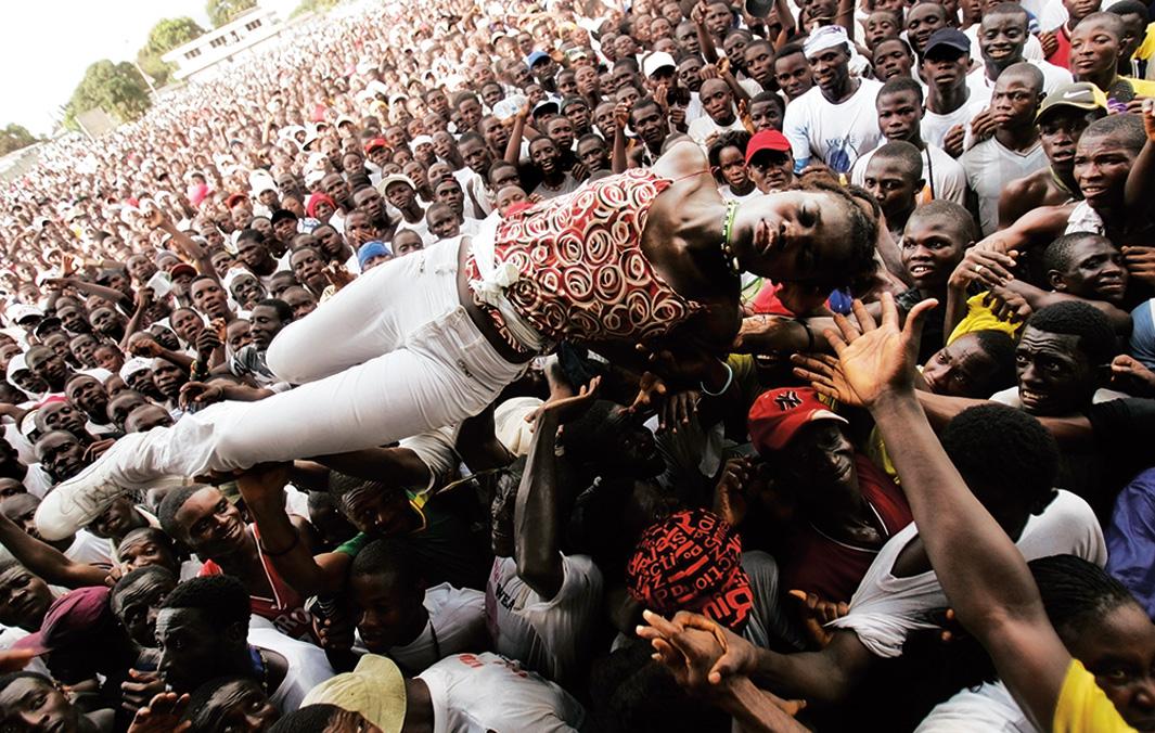 An unconscious woman is carried by supporters of Liberian presidential candidate George Weah after she fell ill from heat and lack of water on Oct. 8, 2005, in Monrovia, Liberia. The massive rally, held by former international soccer star Weah at his headquarters, attracted hundreds of thousands of supporters on a brutally hot day, with many collapsing from heat and thirst.