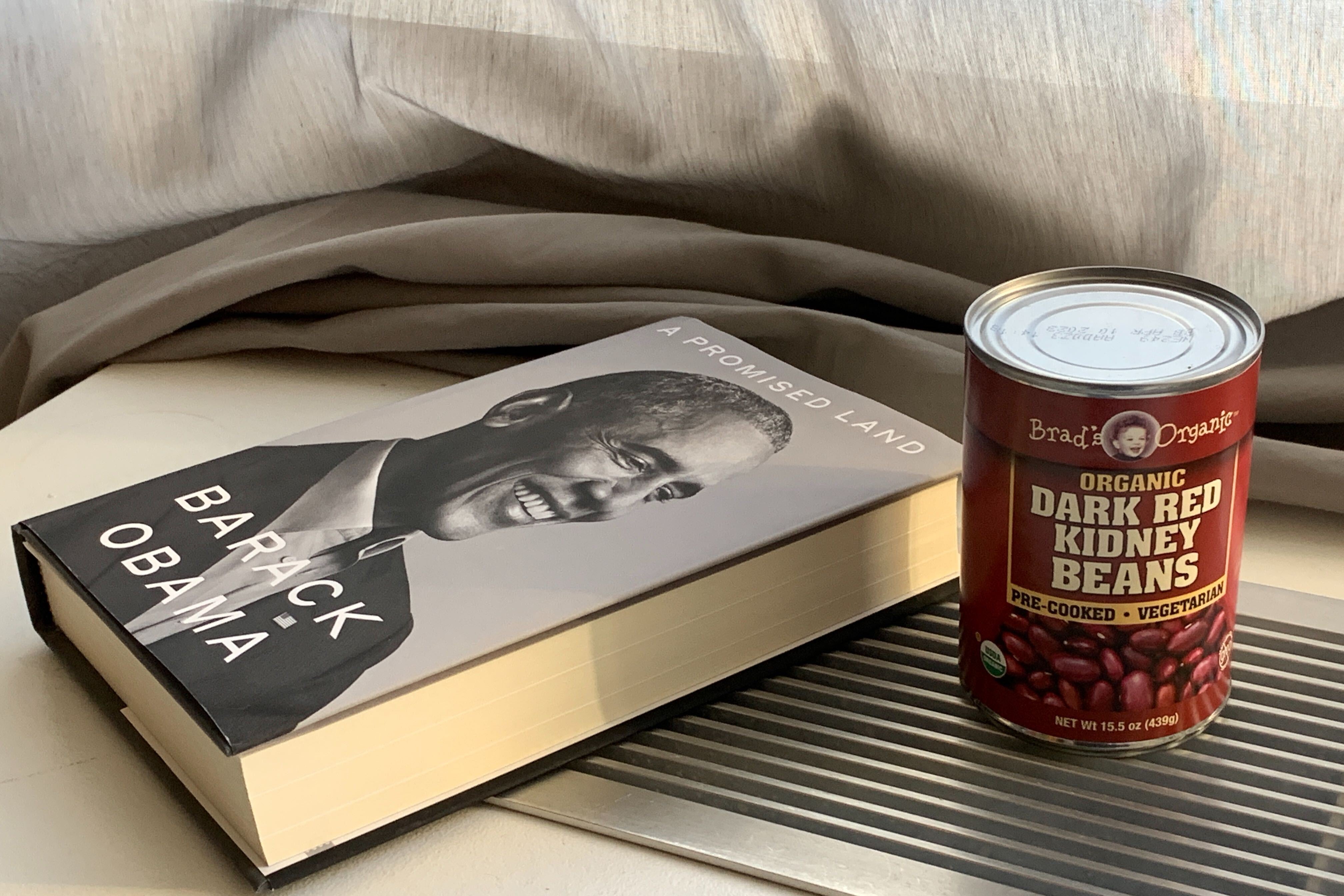 Against a gray curtain backdrop, Barack Obama's new book lies on its side in the sunlight, next to a can of red kidney beans.