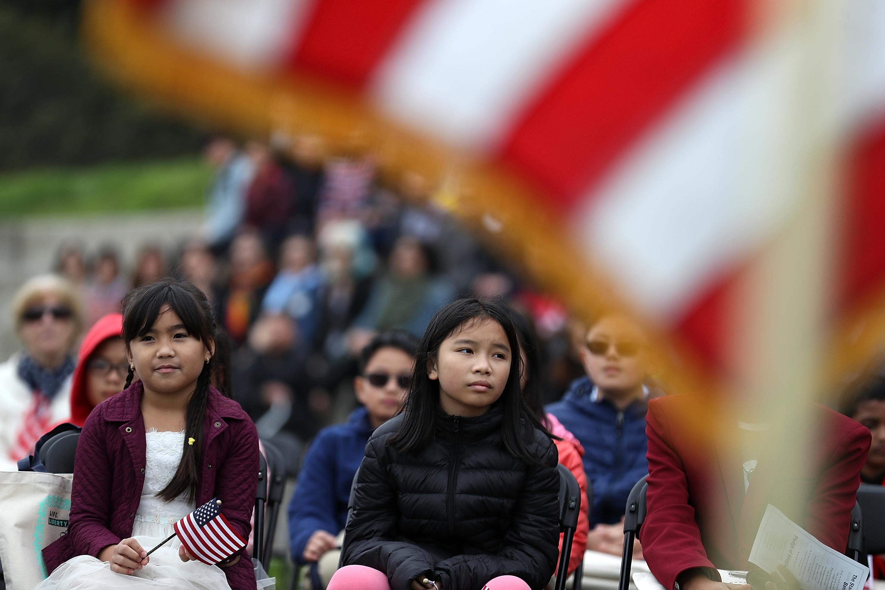 Children look on during a naturalization ceremony for kids between the ages of 6-12 at Crissy Field near the Golden Gate Bridge on August 17, 2018 in San Francisco, California.