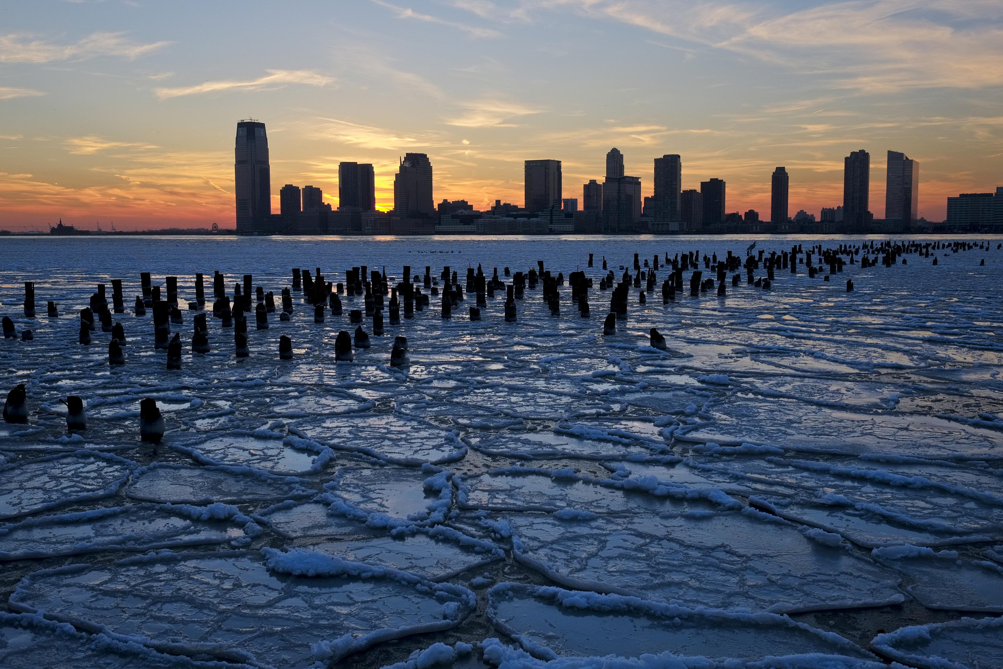 Ice floes fill the Hudson River as the New Jersey waterfront is seen during sunset in New York City. 