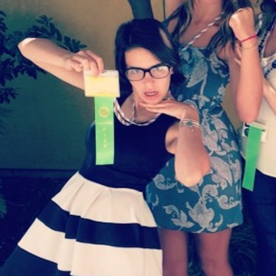 Teen girl doing a silly pose with her green ribbon