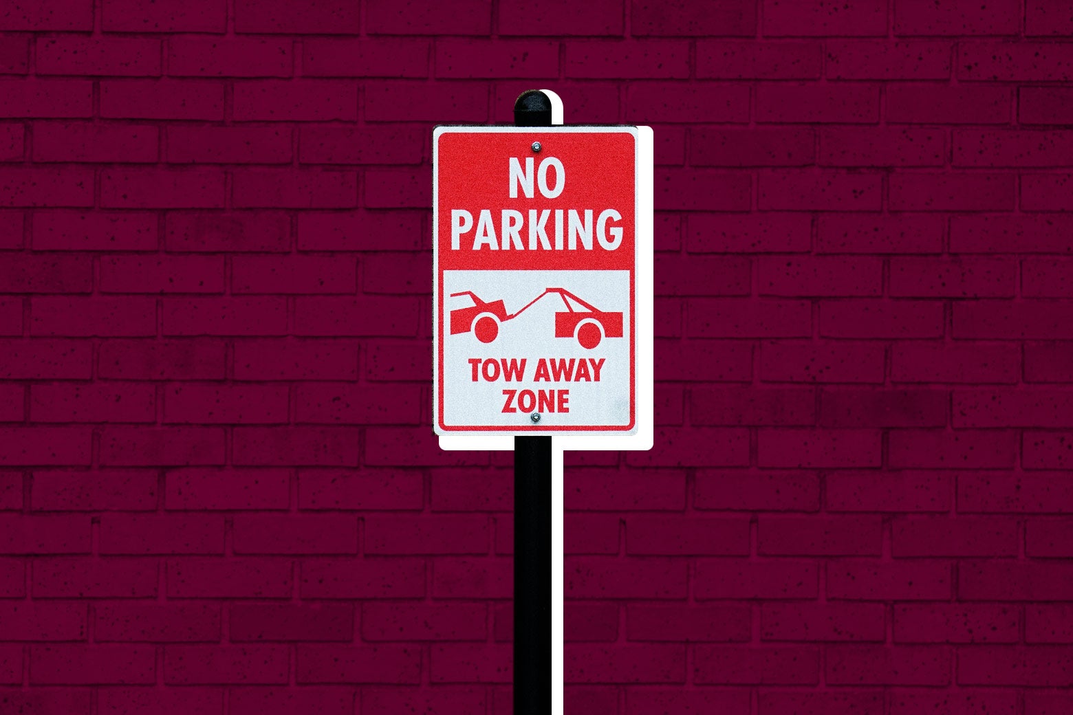 Photo illustration: a "No Parking–Tow Away Zone" sign against a brick background.