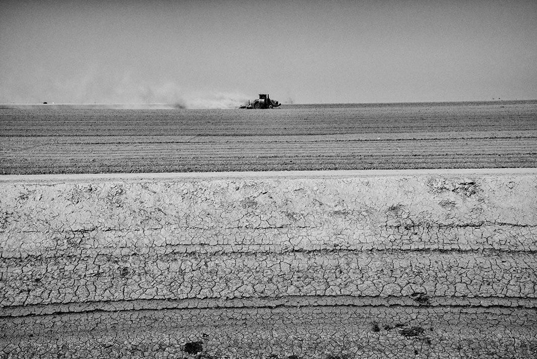 A tractor tills dry land near the Tulare Lake basin.