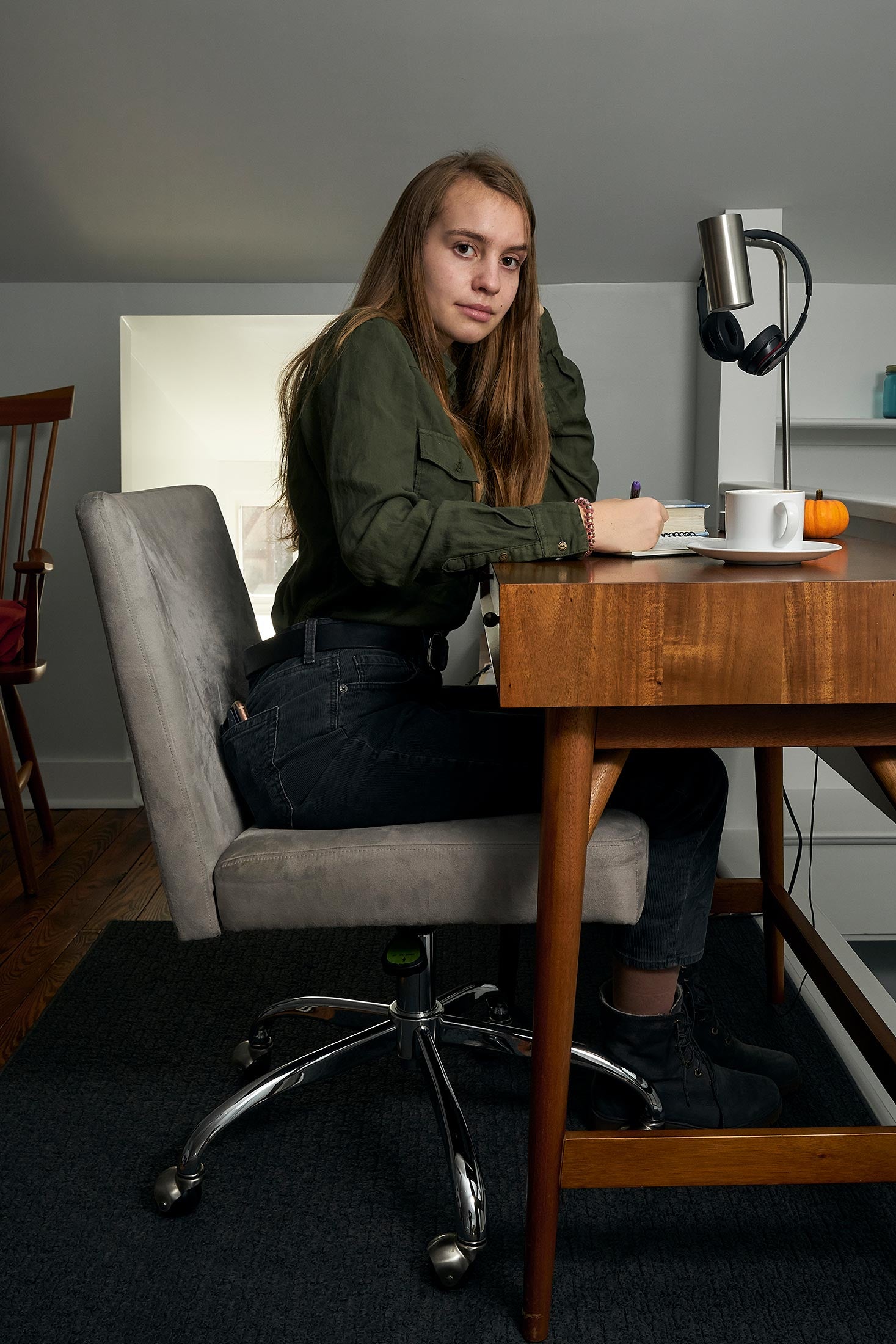 Margot, sitting at a desk at home, 12th grade.