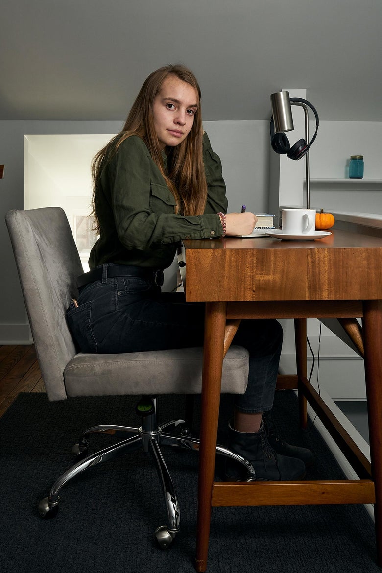 Margot, sitting at a desk at home, 12th grade.
