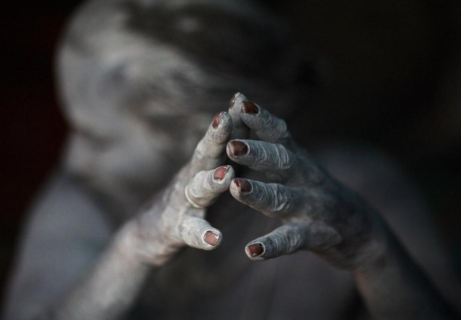 The ash-encrusted hands of a sadhu (Hindu holy man) are seen as he sits beside a fire after applying ashes to his face and body at his ashram at Pashupatinath Temple in Kathmandu, Nepal, March 4, 2013. 