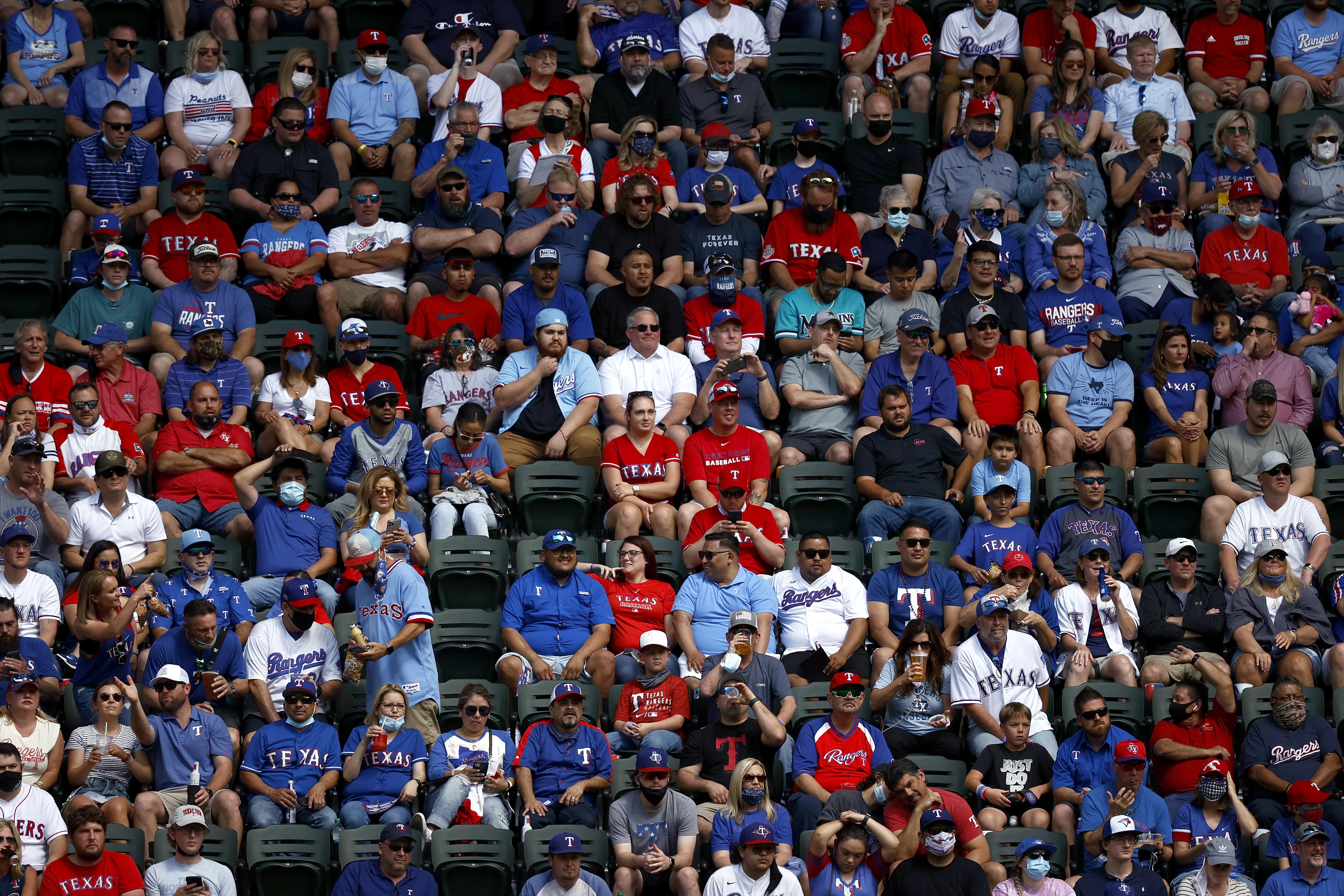 Mostly maskless fans sit shoulder to shoulder in the stands
