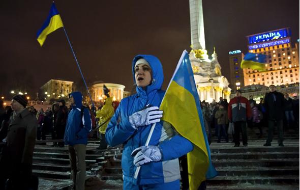 A woman sings the national anthem during a rally on Independence Square.