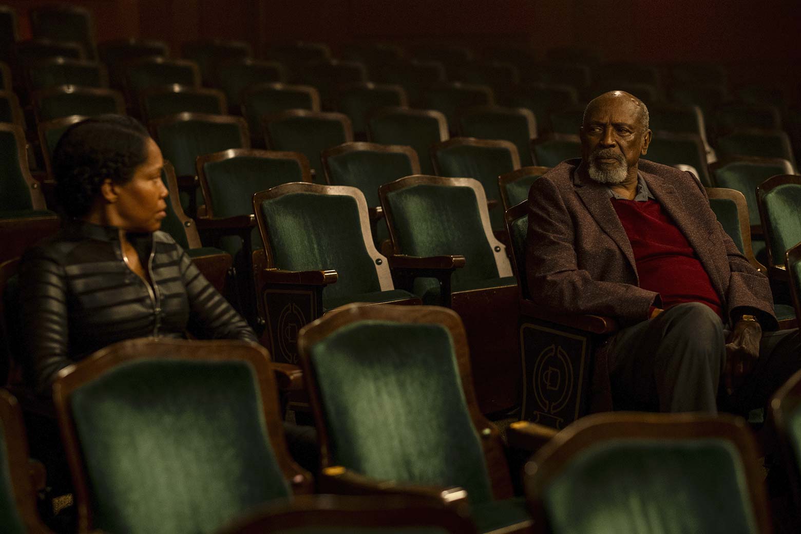 Regina King and Louis Gossett Jr. stare at each other across auditorium seating in this still from Watchmen.