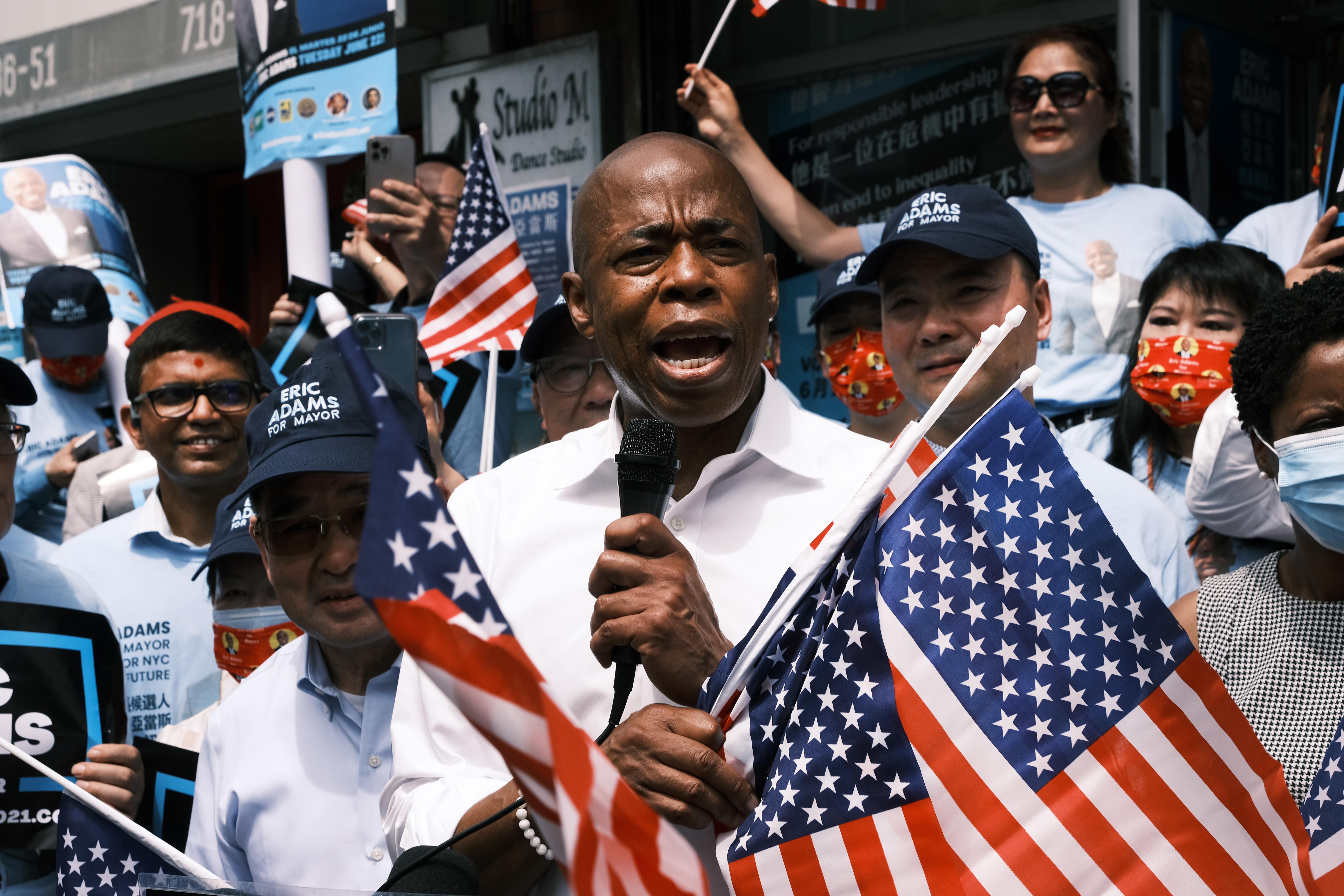 Brooklyn Borough President Eric Adams appears in Flushing, Queens to open a new campaign office on June 8, 2021 in the Queens borough of  New York City. He's seen surrounded by a crowd of supporters who are waving American flags.
