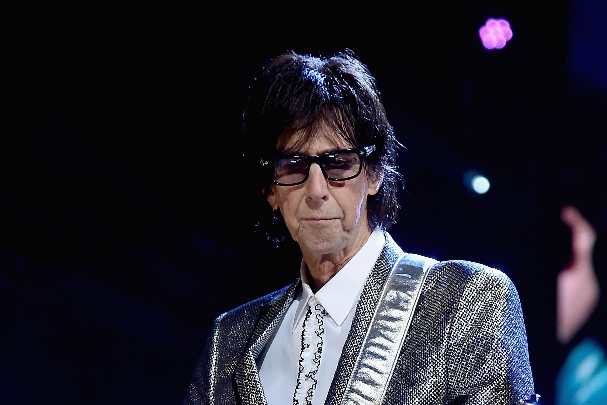 Ric Ocasek playing a guitar on stage.