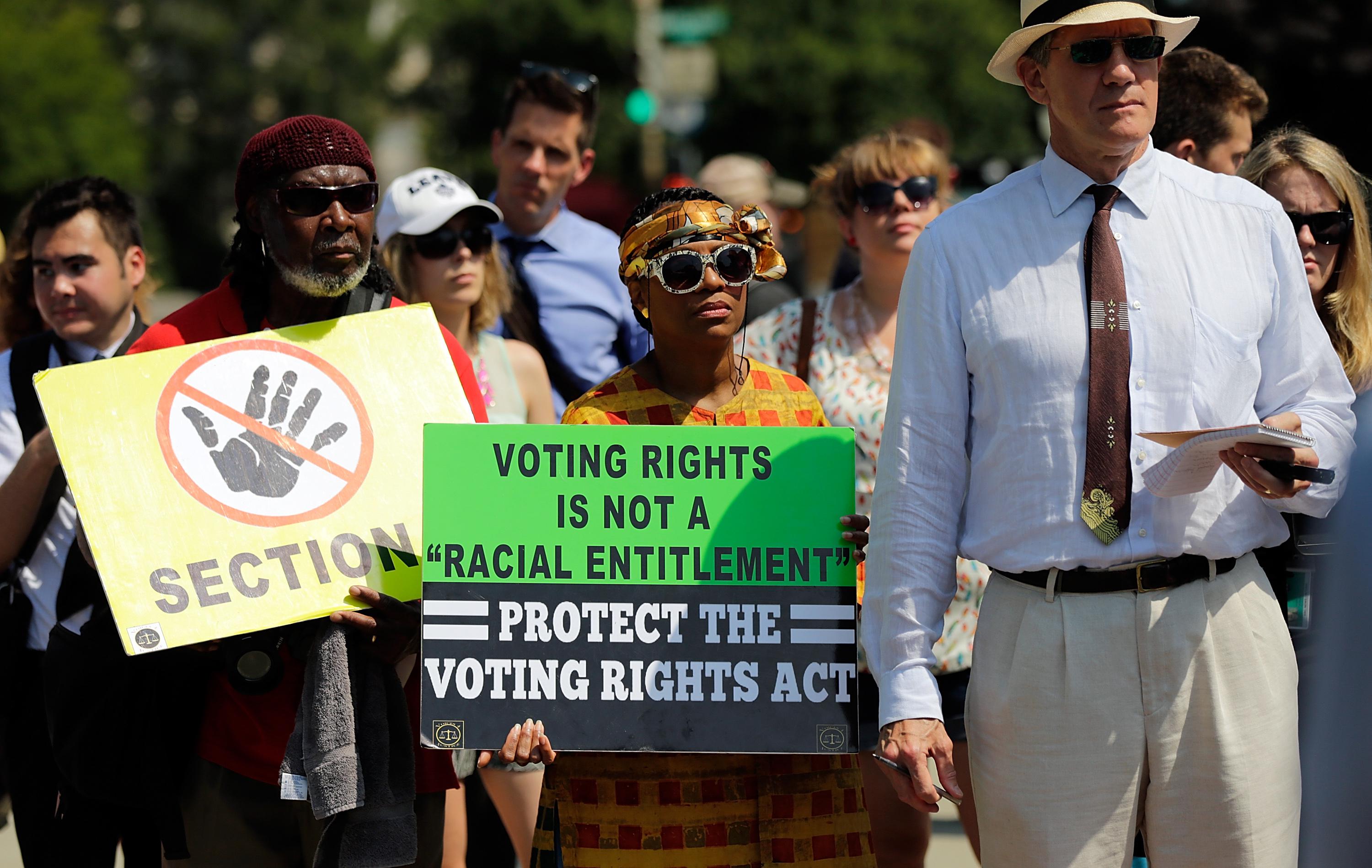 A crowd of protesters gathers with signs in support of the Voting Rights Act
