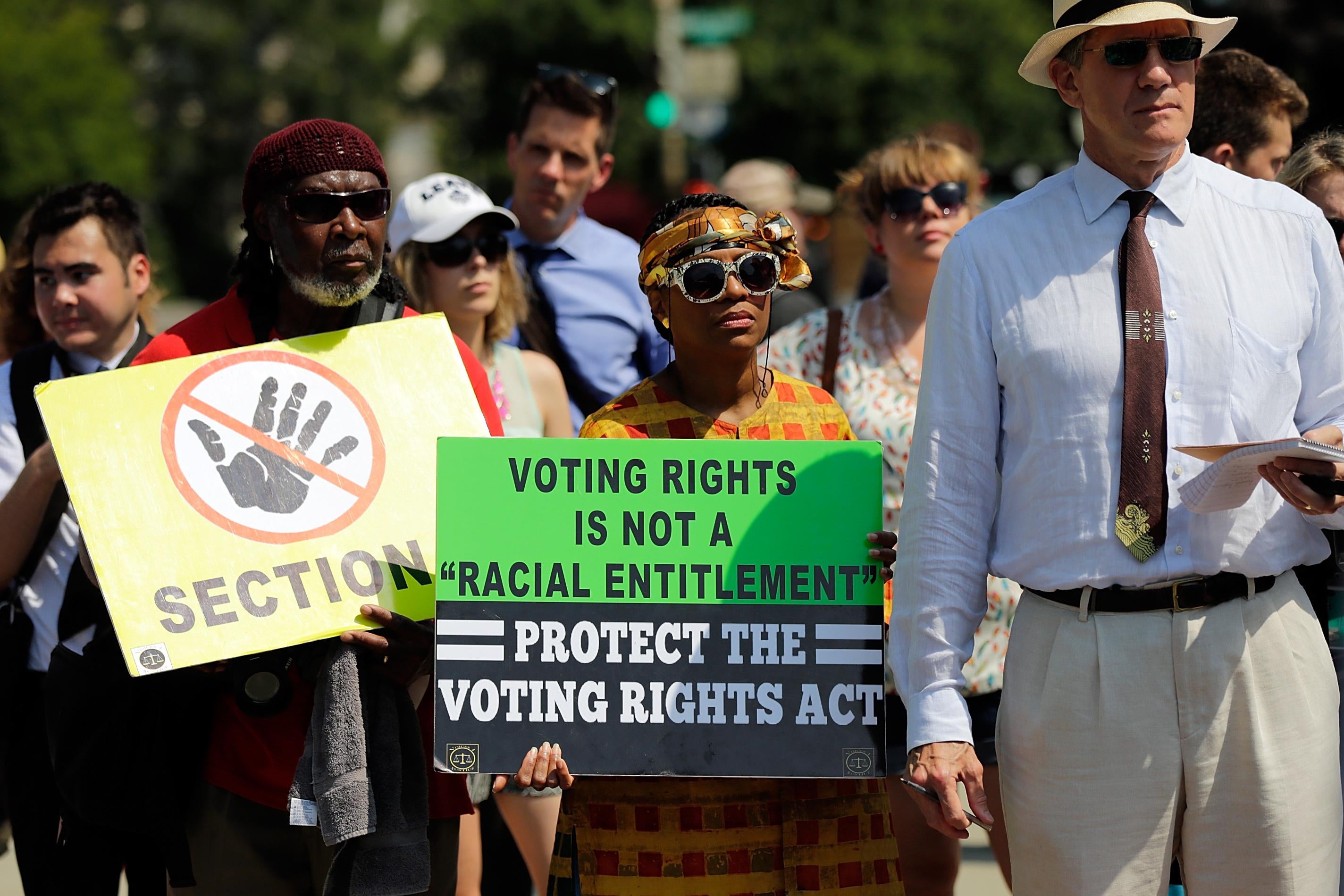 A crowd of protesters gathers with signs in support of the Voting Rights Act