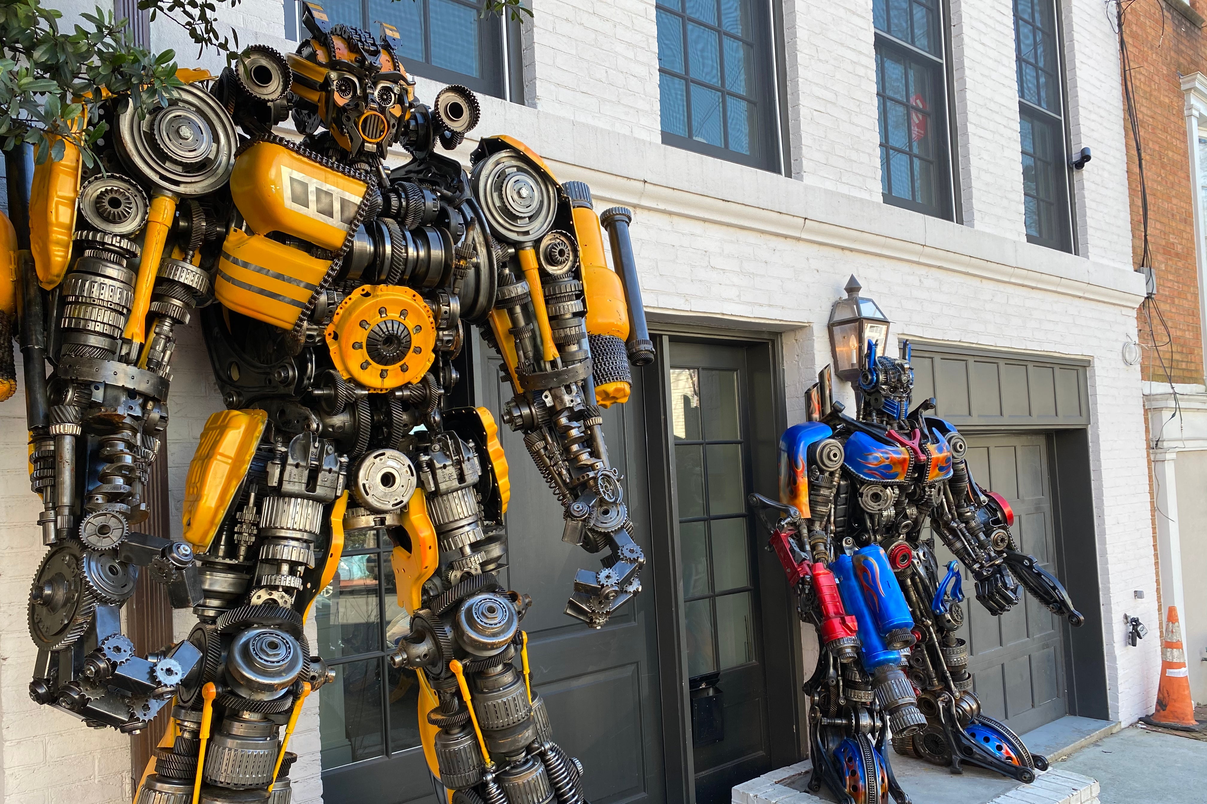 Two large robot statues flank the front door of a white Georgetown row house.