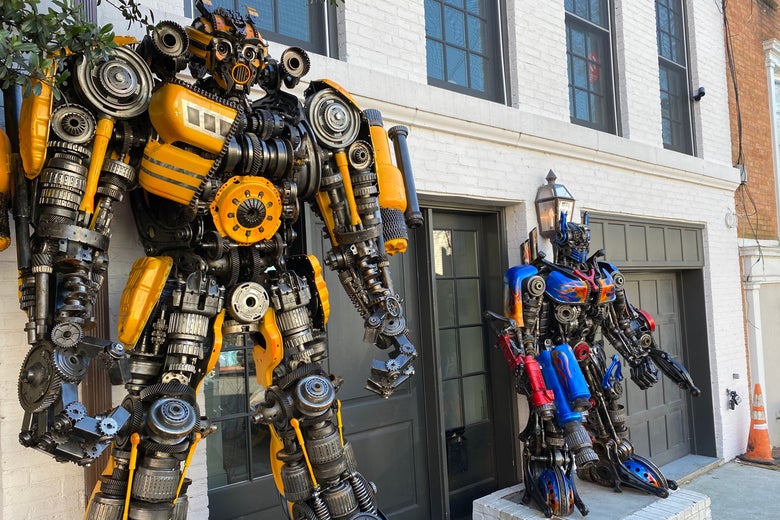 Two large robot statues flank the front door of a white Georgetown row house.