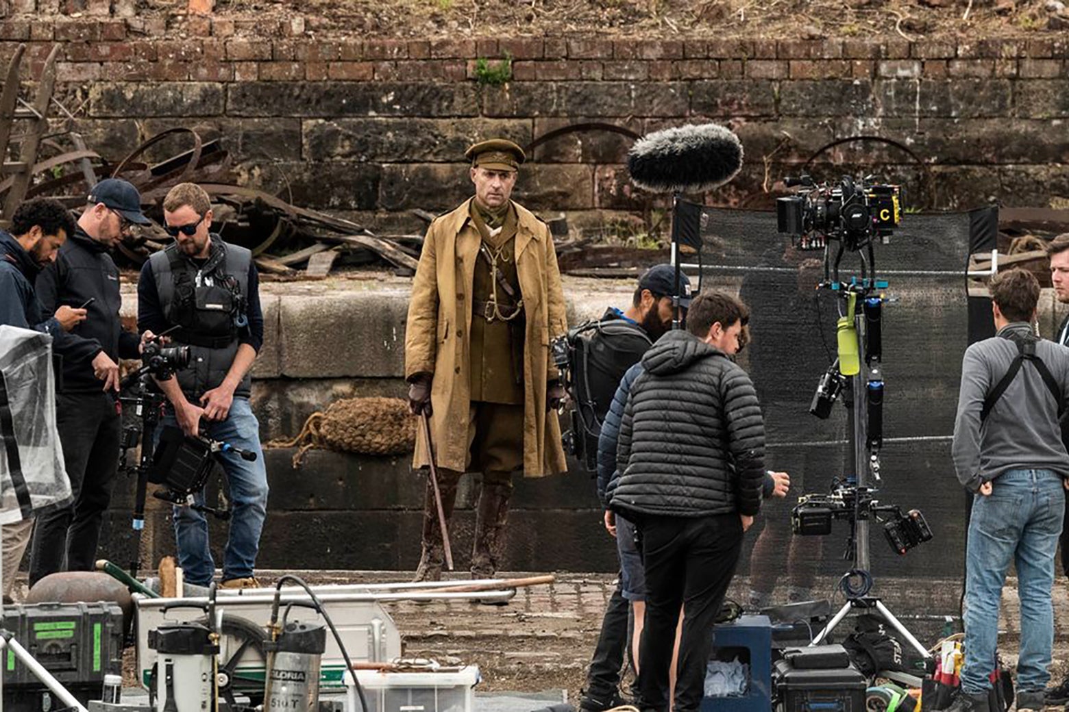 A production still from 1917, showing actor Mark Strong, in costume, surrounded by cameras and crew.