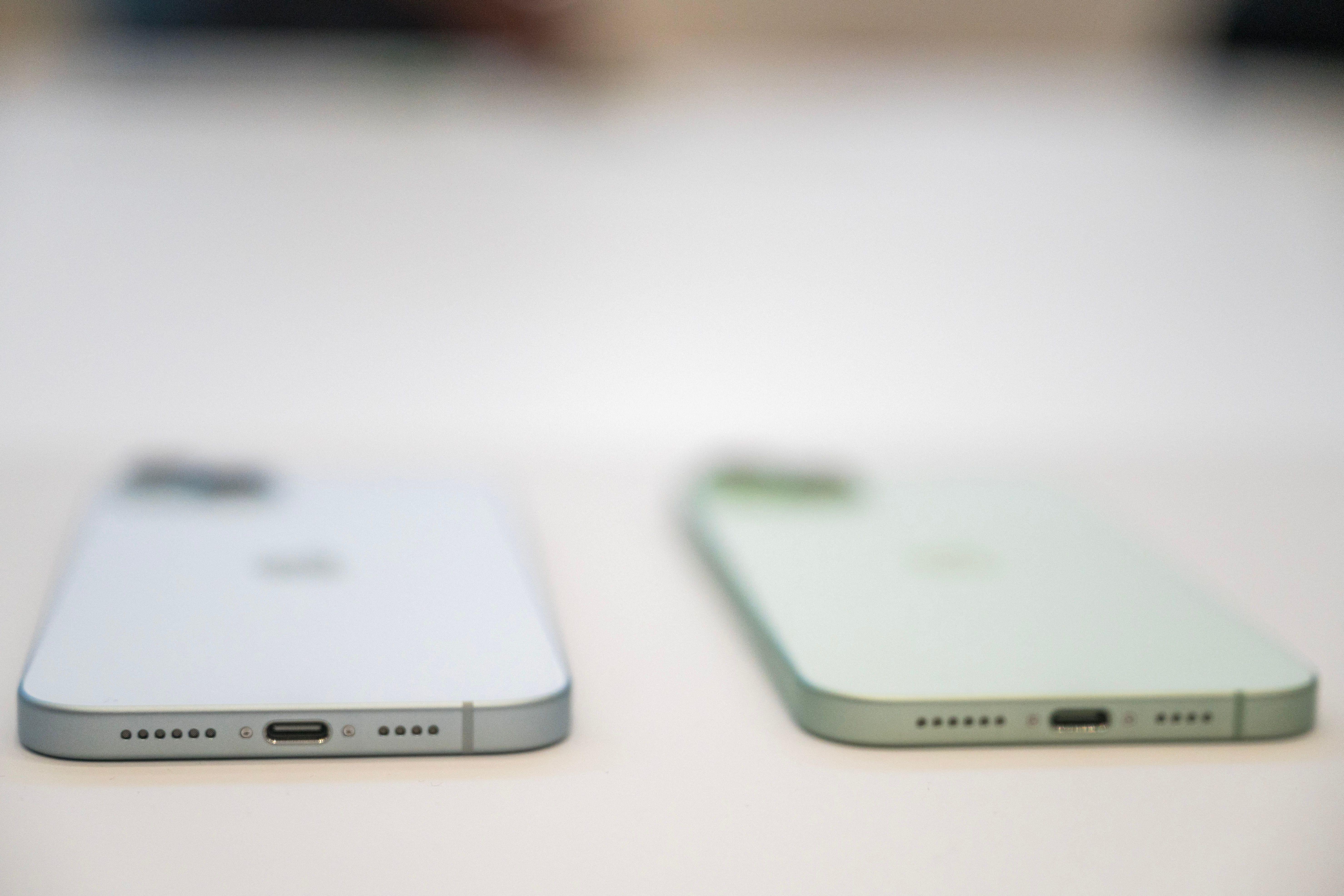 Two blurry face-down iPhones, with the focus clearer around their USB-C charging ports