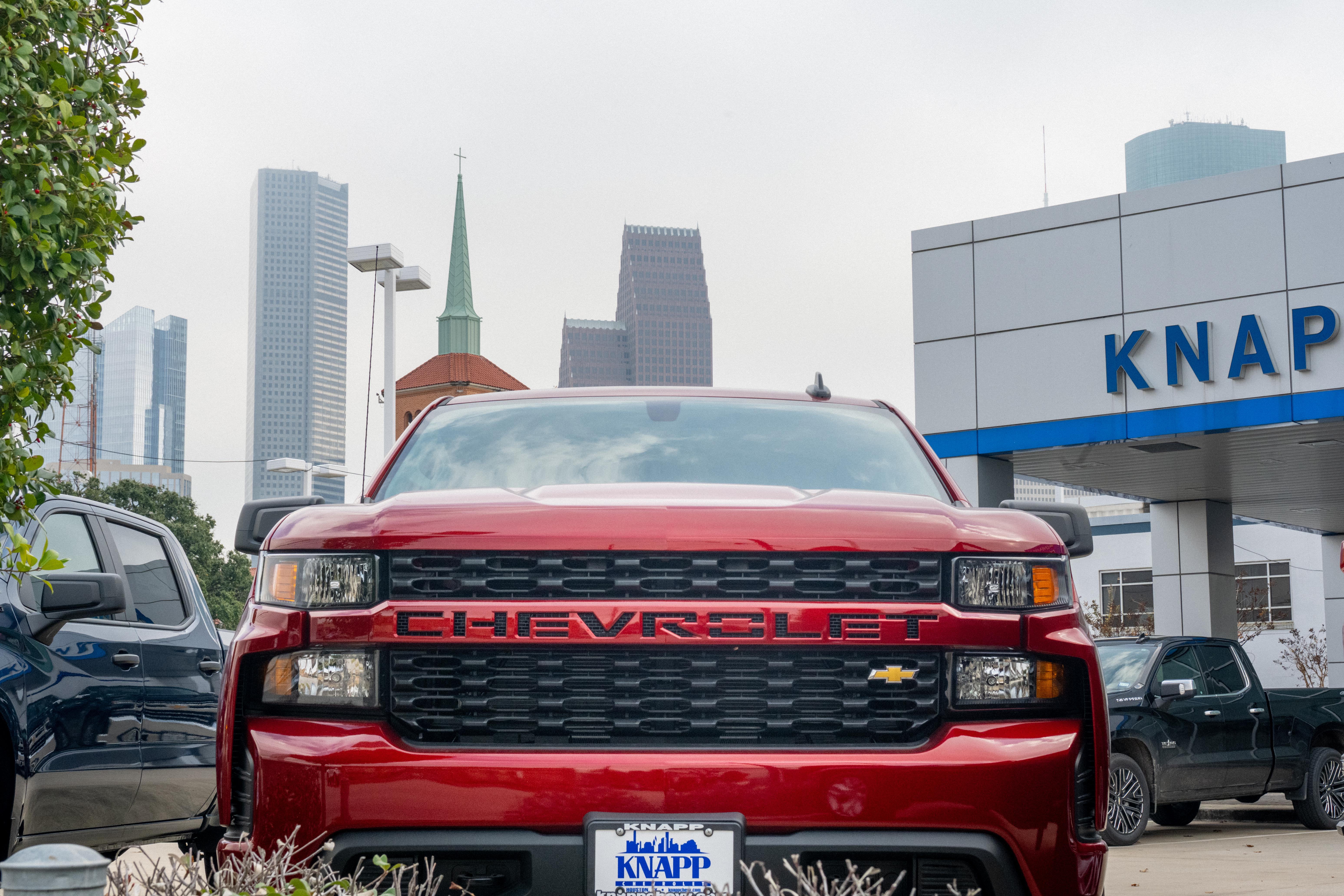 Front view of a red Chevrolet pickup truck parked at a dealership
