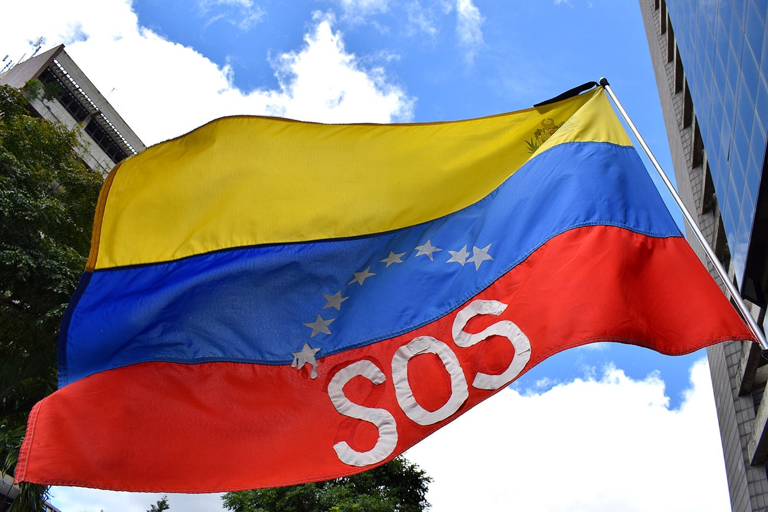 An SOS flag flies above protesters at a July 2019 march in Caracas.
