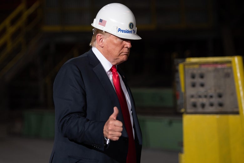 President Donald Trump wearing a hard hat, giving a thumbs up