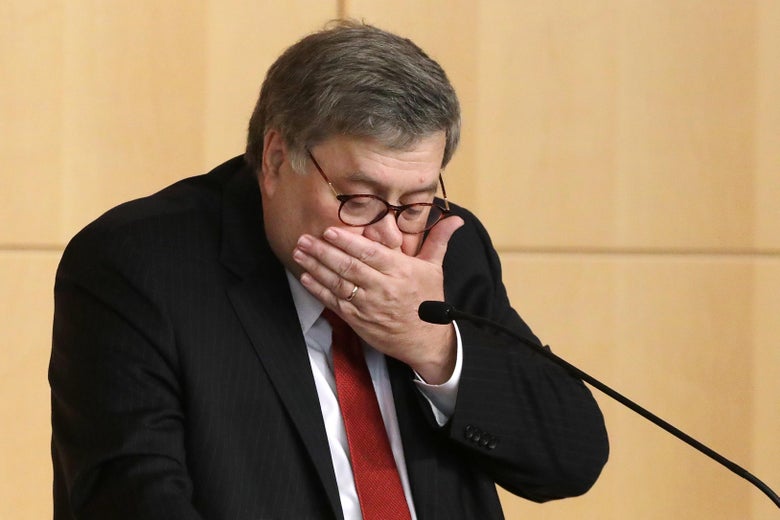 Attorney General William Barr holds his hand over his mouth.