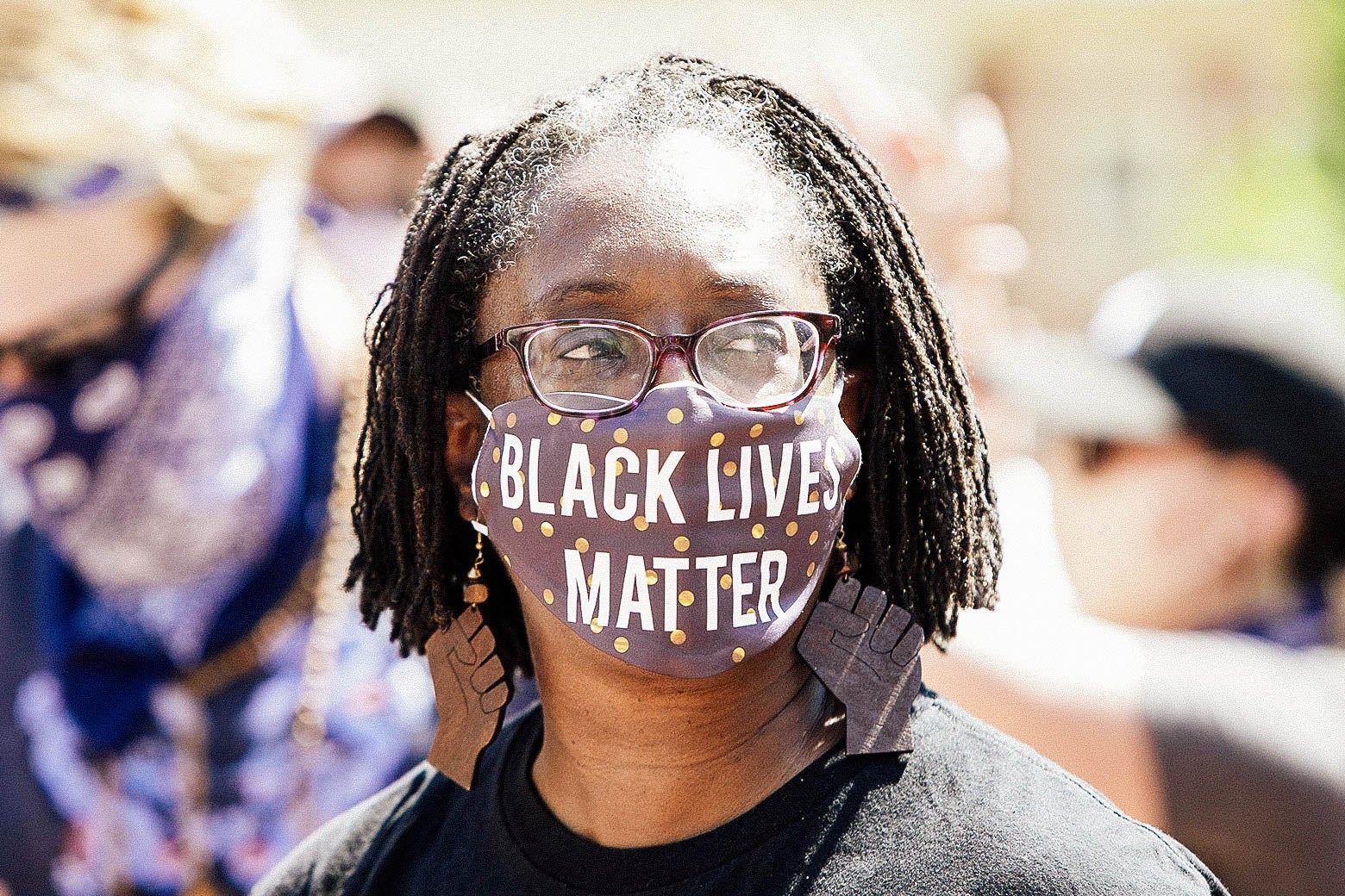 A woman wearing a mask that says Black Lives Matter.