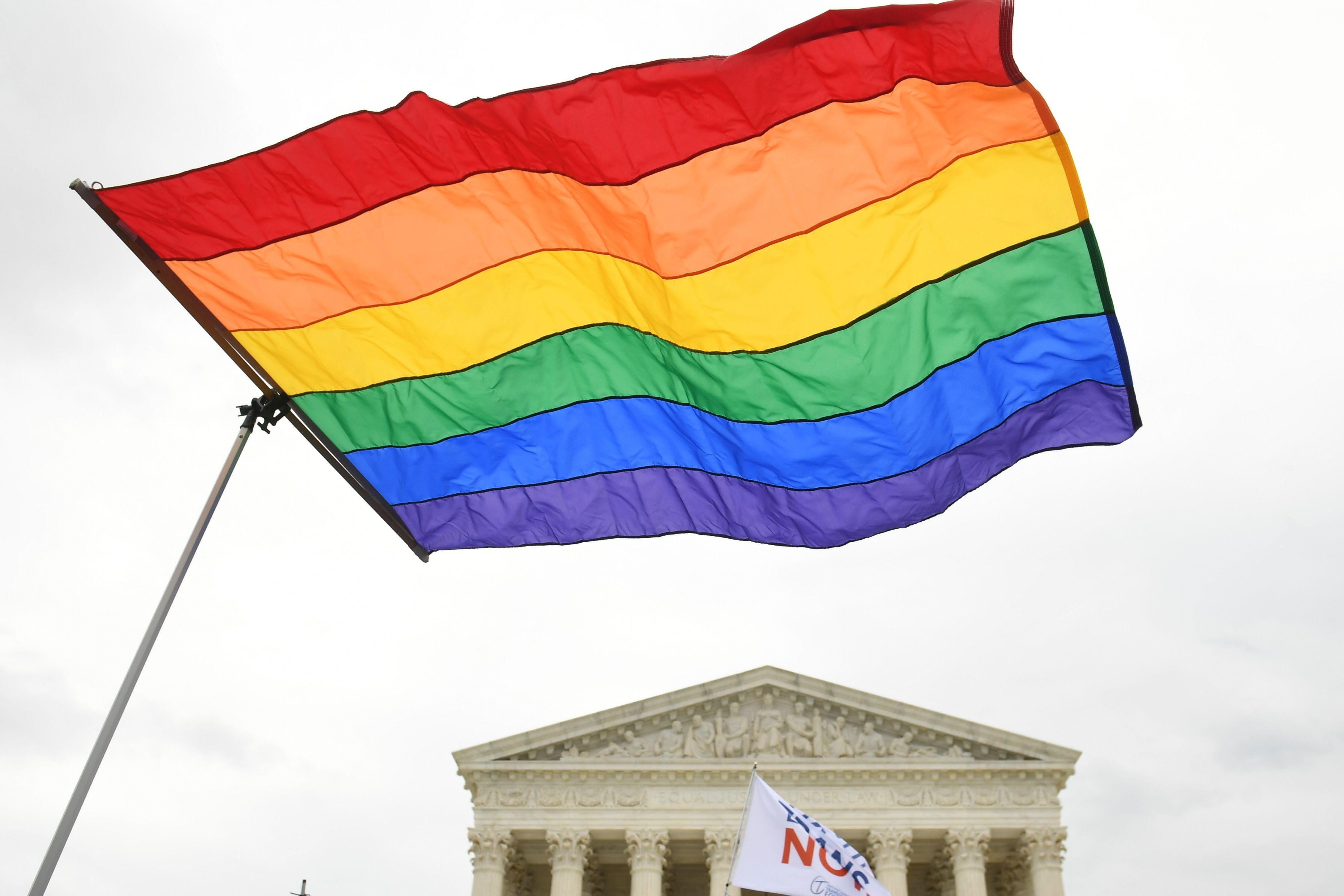 Demonstrators wave a rainbow flag in support of LGBTQ rights outside the Supreme Court.