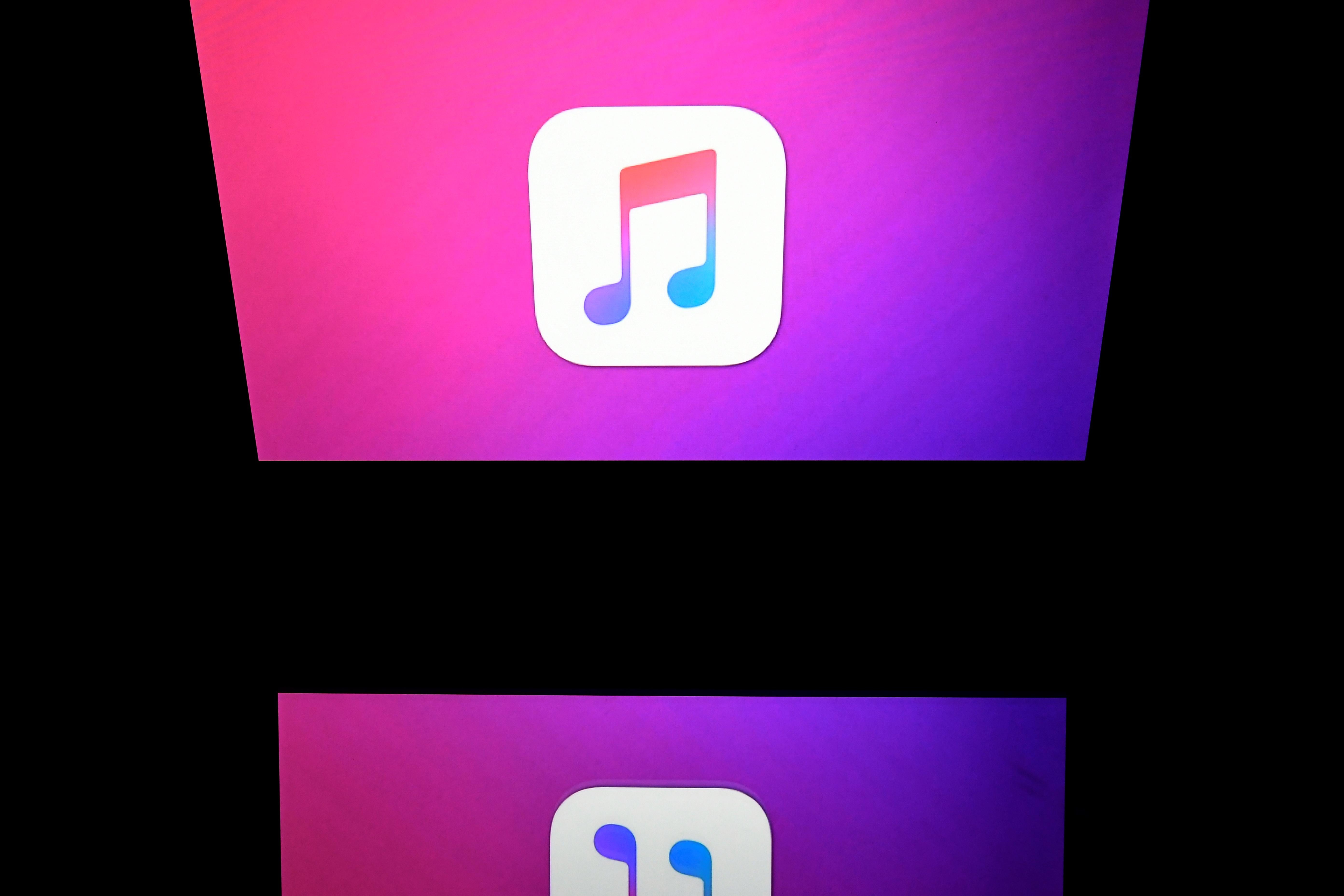 The iTunes logo on a screen onstage.