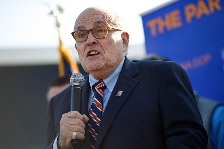 Rudy Giuliani holding a microphone.