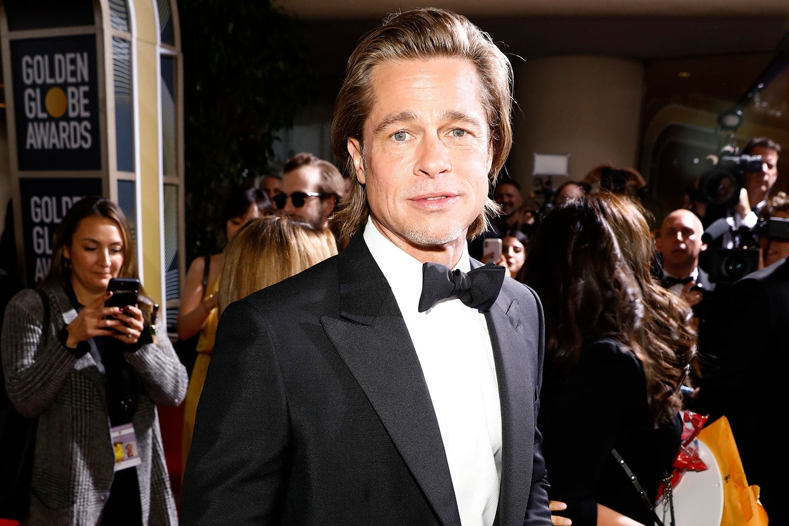 Brad Pitt, in a tux on the red carpet, looks at the camera with a slight smile.