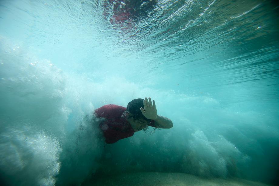A bodysurfer punches through a wave at the Ehukai sandbar near the surf break known as 'Pipeline' on the North Shore of Oahu, Hawaii on March 20, 2013.