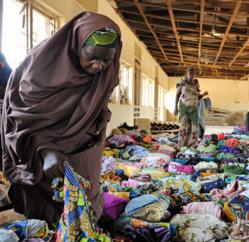 A woman examines clothes donated by humanitarians to be distributed to displaced people at Hajj Camp in Kaduna on April 26, 2011.