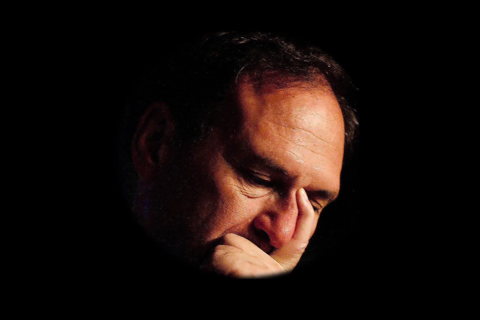 Justice Samuel Alito with a hand covering the left side of his face.