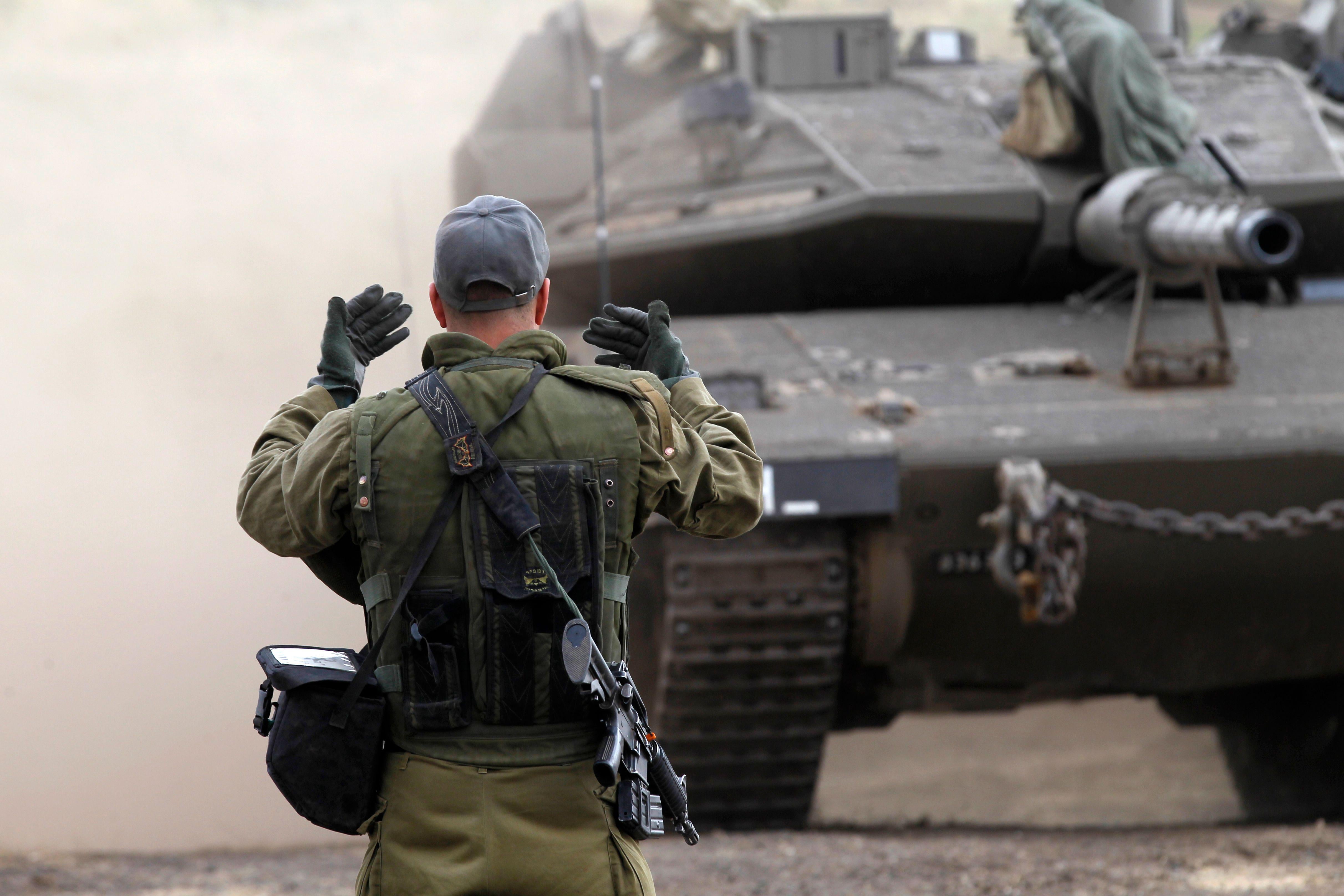 An Israeli soldier waves on a Merkava Mark IV tank.