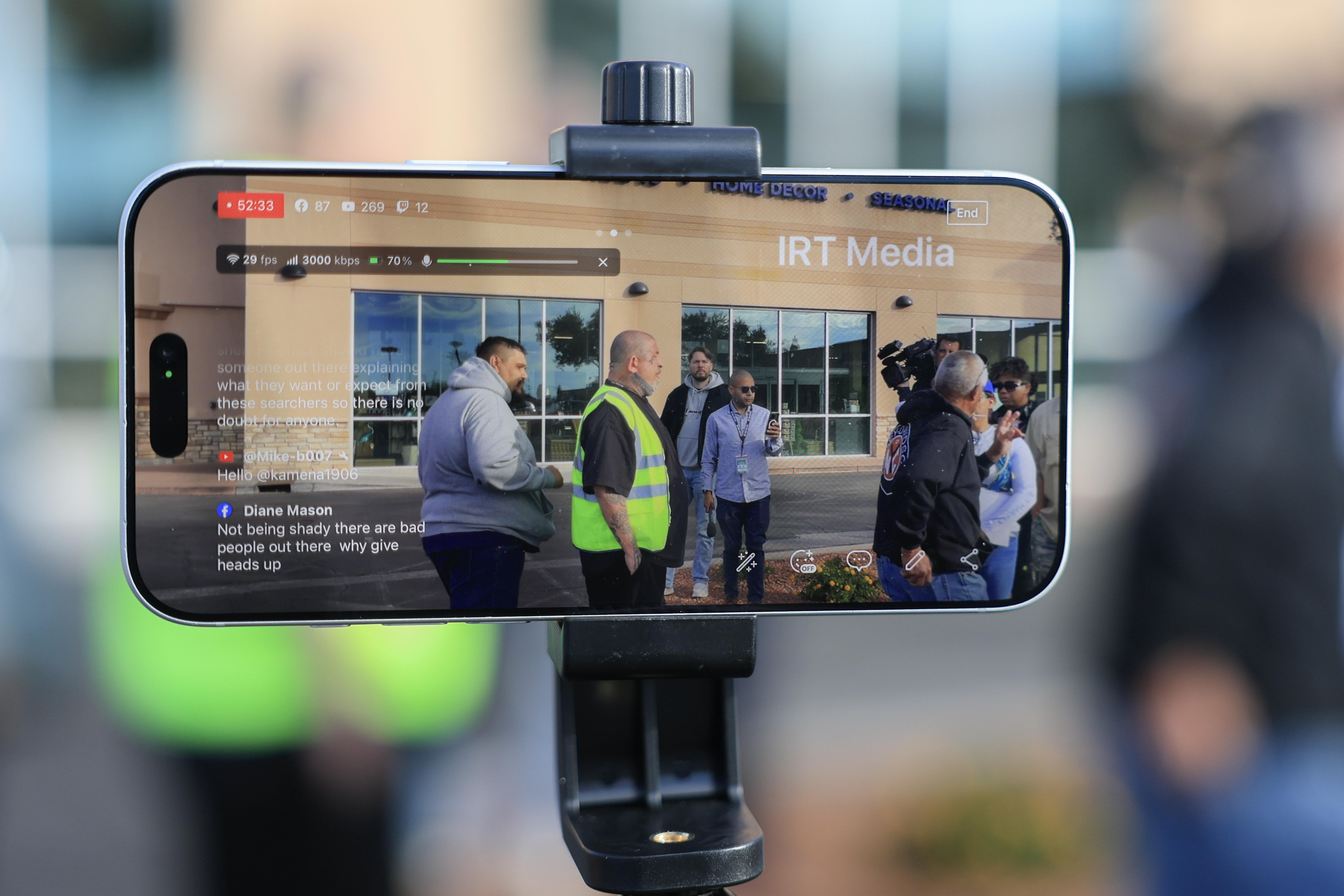 TUCSON, ARIZONA - FEBRUARY 22: Volunteers are seen on a live streaming iPhone as they gather to search for any possible signs of Nancy Guthrie near her residence on February 22, 2026, in Tucson, Arizona. The volunteer group was looking for anything that could help find Nancy Guthrie or the person or persons responsible for her disappearance. Law enforcement officials continue to search for Nancy Guthrie, the 84-year-old mother of U.S. journalist and television host Savannah Guthrie, after she went missing from her home on the morning of February 1st. (Photo by Joe Raedle/Getty Images)