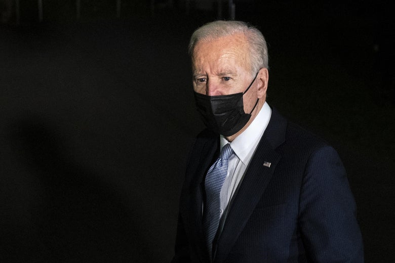 Joe Biden wearing a black mask outside at night