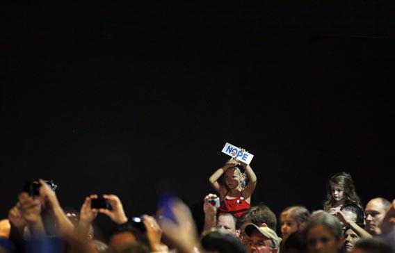 A girl holds up a sign reading "NOPE" while Republican presidential candidate and former Massachusetts Governor Mitt Romney speaks to the overflow room at a campaign rally in Cincinnati, Ohio September 1, 2012.