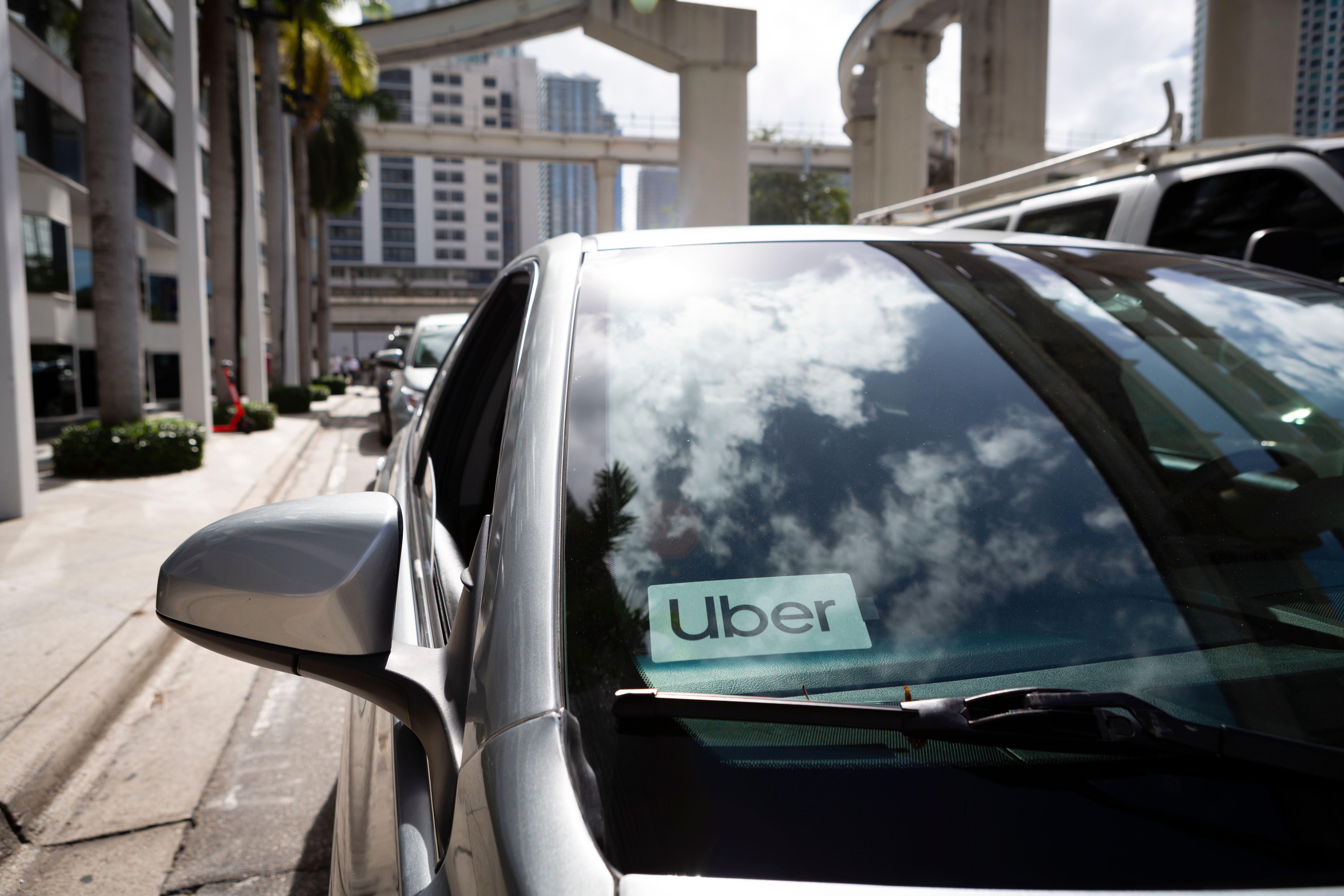 An Uber sticker is seen on a car windshield.